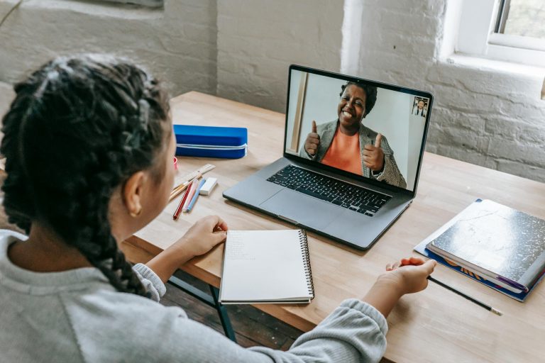 A young student connecting with a teacher via video call for an online lesson.